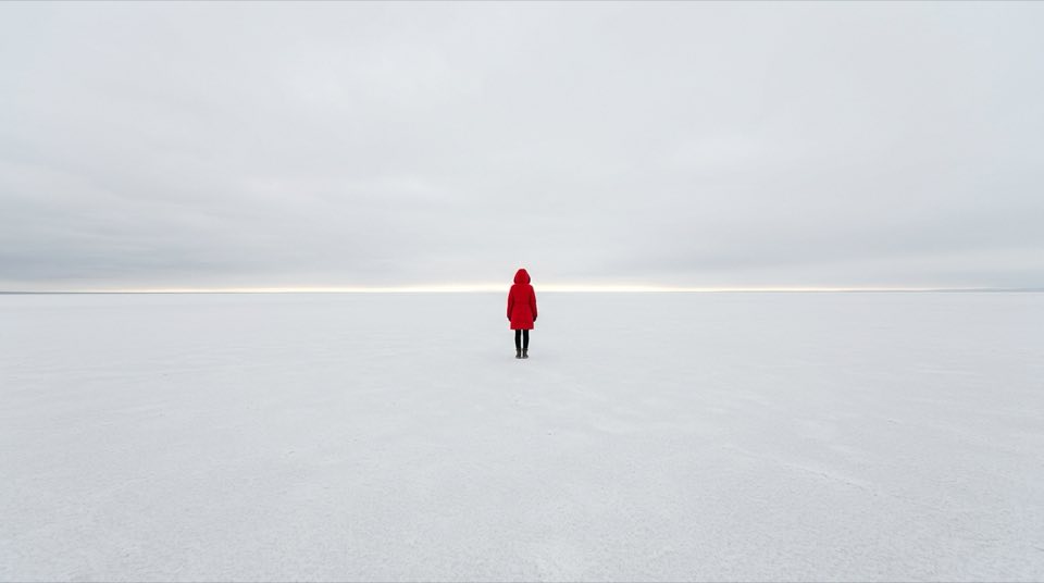 A single [character] standing in a vast empty [environmen…